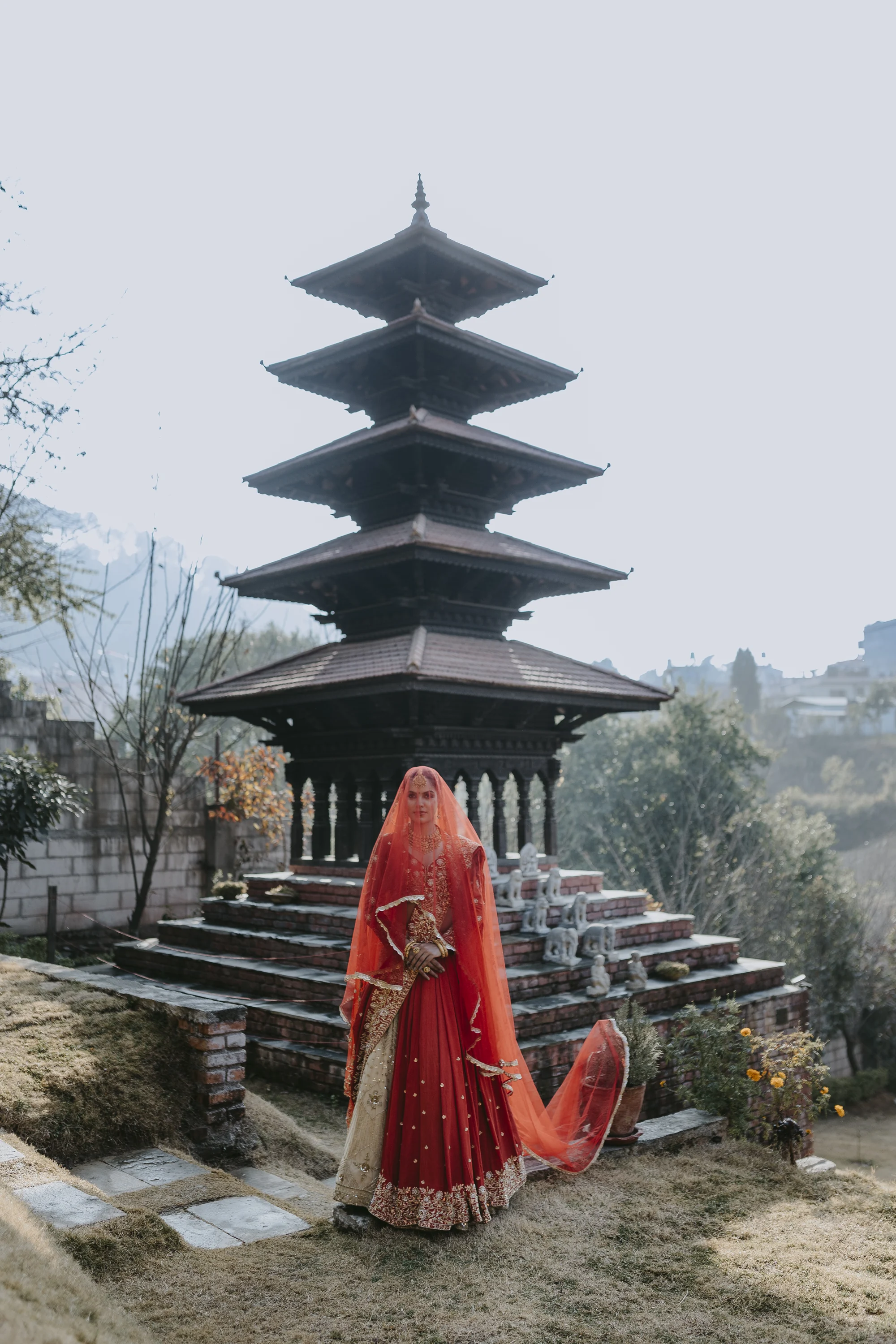Bride in red beneath a Kathmandu pagoda