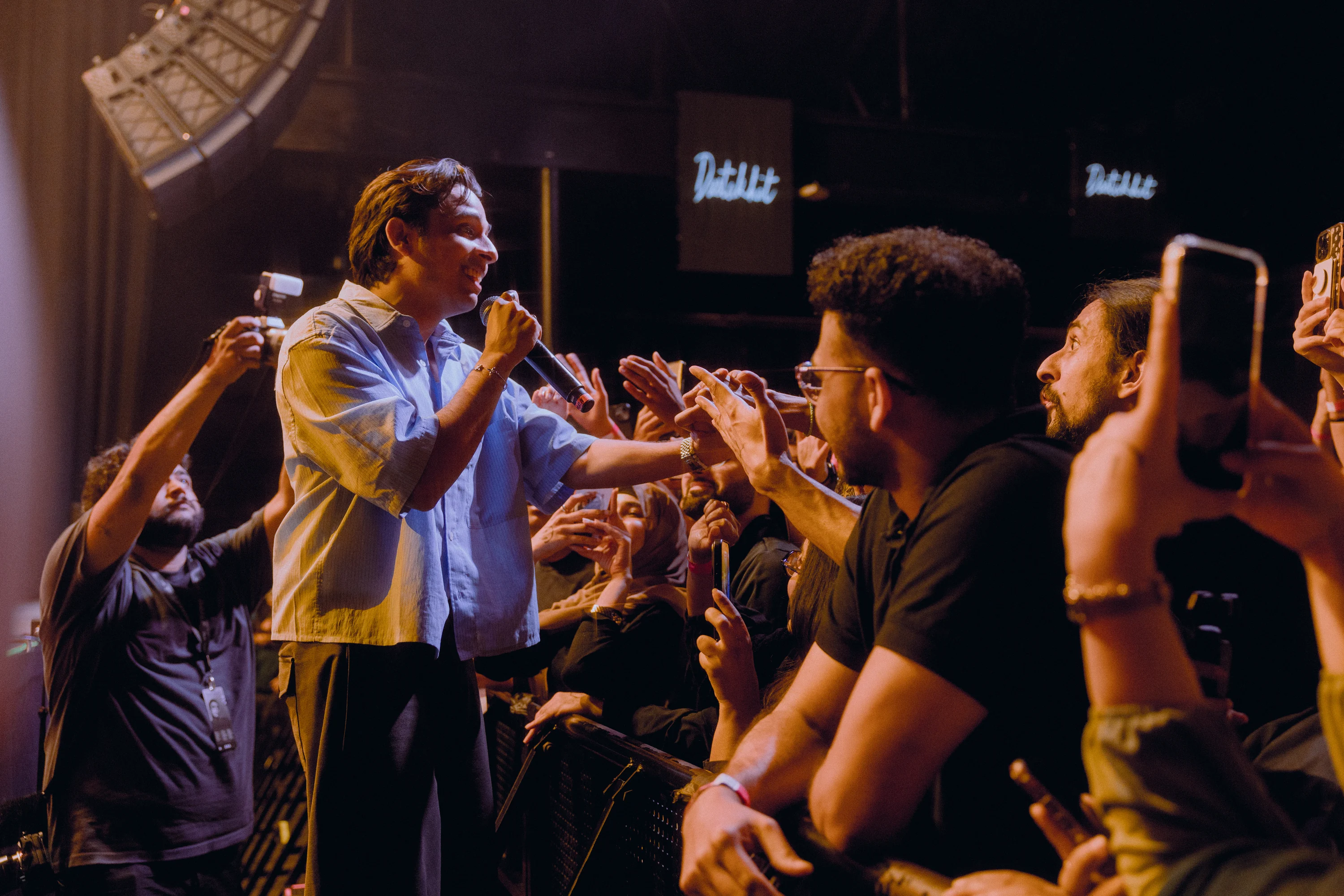 Performer meeting the audience at the edge of a live stage